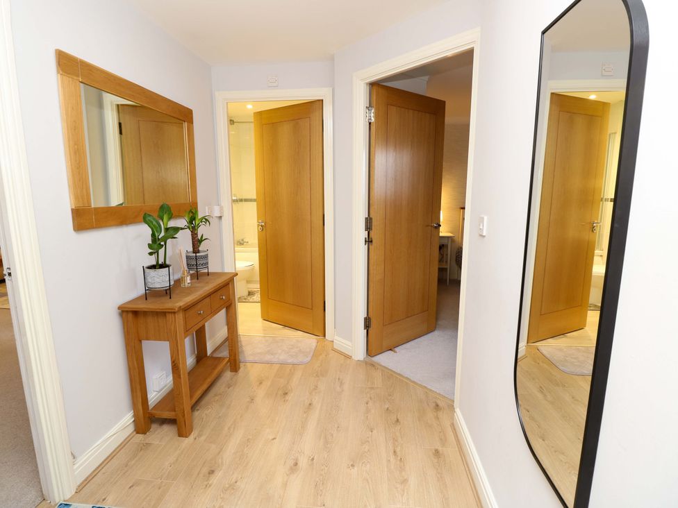 A hallway with a table and mirror at 53 Orchard Place