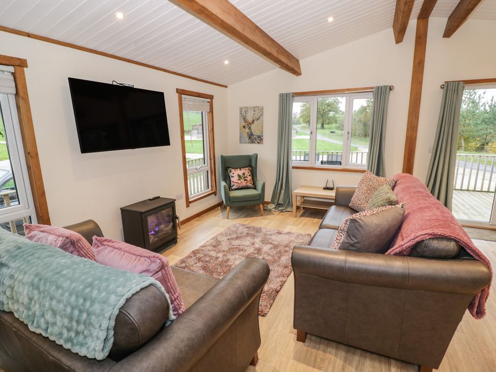 A living room with a sofa and a fireplace at Oak Lodge Admaston near Abbots Bromley