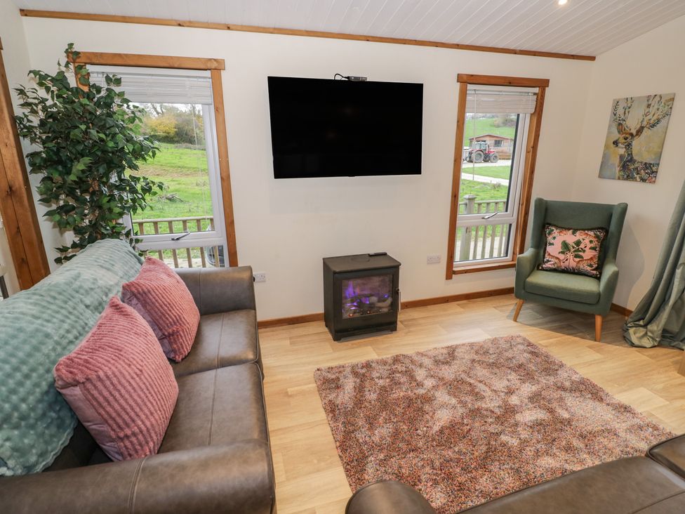 A living room with a television and sofa at Oak Lodge Admaston near Abbots Bromley