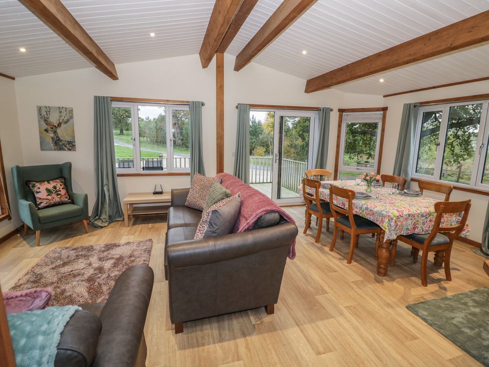 A living room with a sofa and dining area at Oak Lodge in Admaston near Abbots Bromley