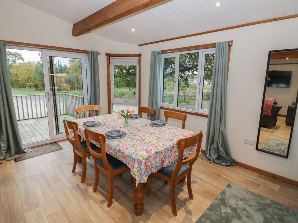 A dining room with a table and chairs at Oak Lodge in Admaston near Abbots Bromley