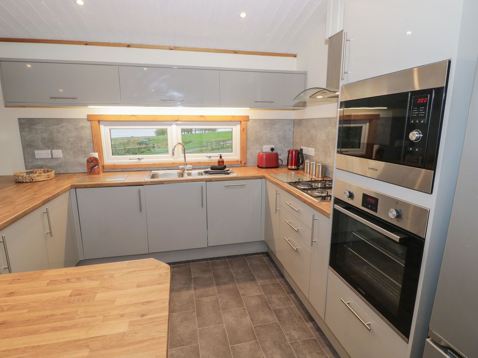 A kitchen with a sink and oven at Oak Lodge in Admaston near Abbots Bromley