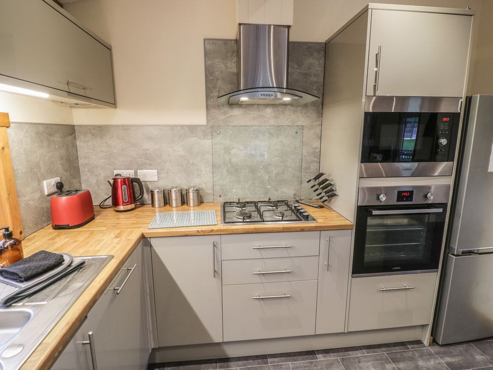 A kitchen with cabinets, gas hob, oven, and kettle at Oak Lodge in Admaston near Abbots Bromley