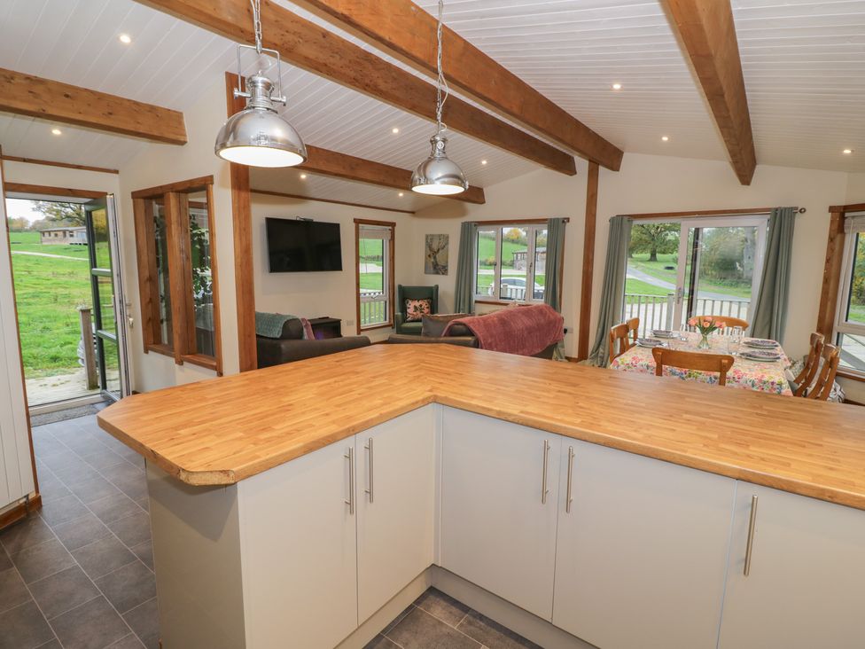 A kitchen with a wooden countertop and dining area at Oak Lodge in Admaston near Abbots Bromley