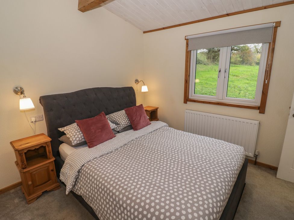 A bedroom with a double bed and bedside tables at Oak Lodge in Admaston near Abbots Bromley