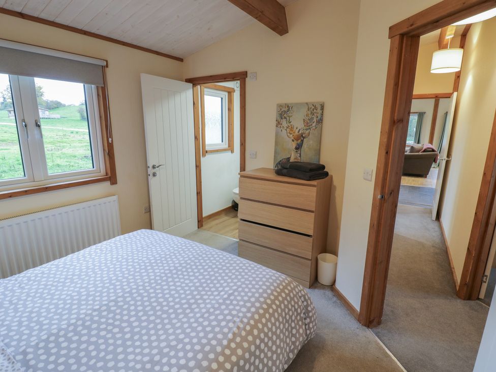 A bedroom with a bed and drawers at Oak Lodge in Admaston near Abbots Bromley