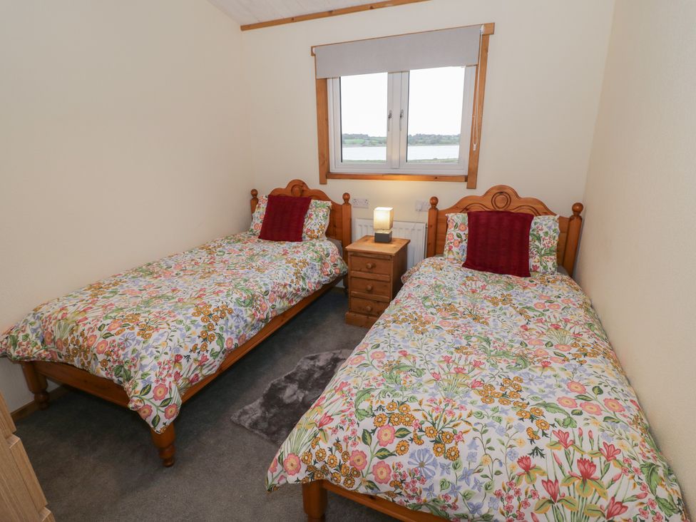 A bedroom with two beds and a window at Oak Lodge in Admaston near Abbots Bromley