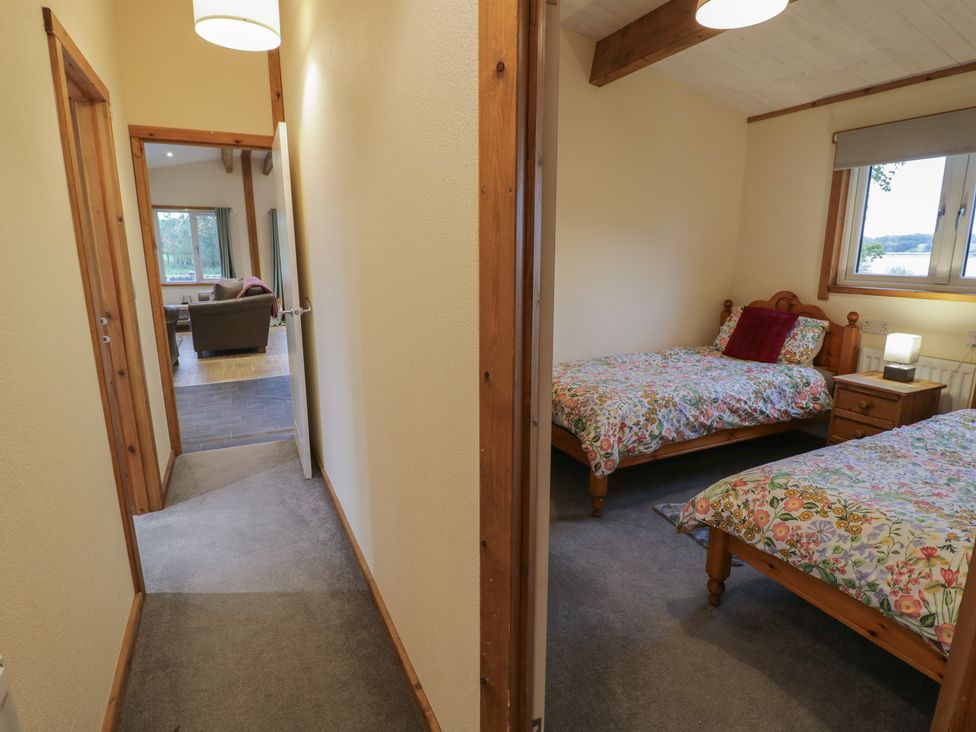 A bedroom with two beds and a nightstand at Oak Lodge Admaston near Abbots Bromley