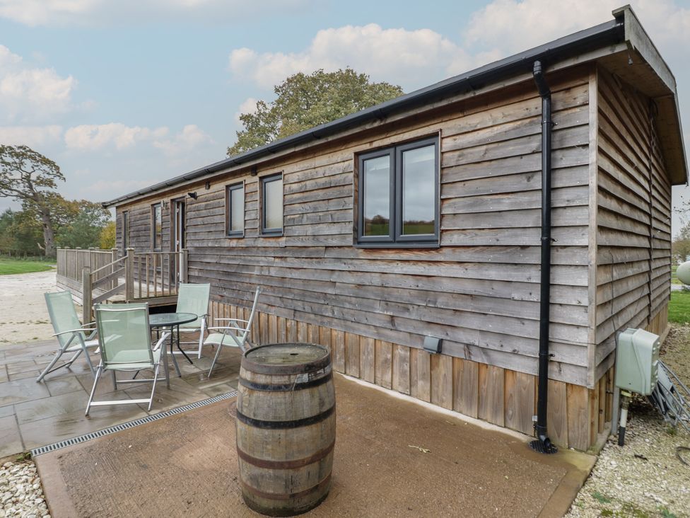 A cabin with chairs and a table outside at Oak Lodge in Admaston near Abbots Bromley