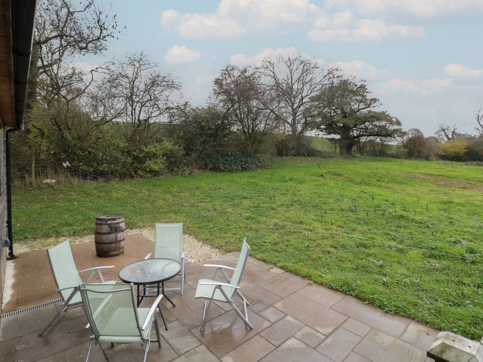 A patio area with a table and chairs at Oak Lodge in Admaston near Abbots Bromley