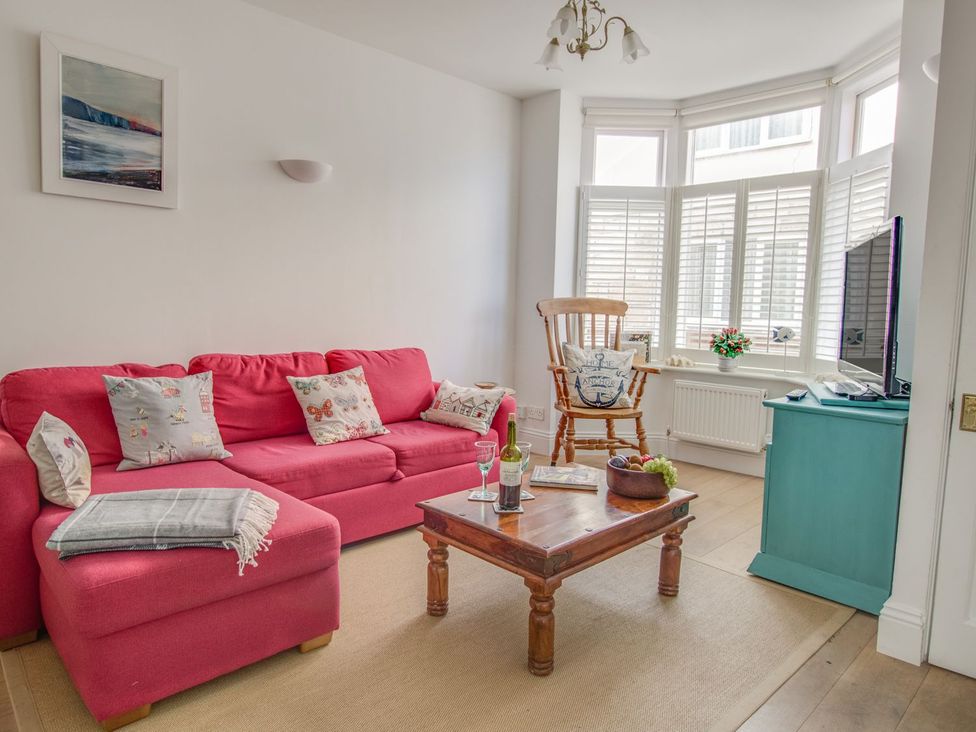 A living room with a sofa and a coffee table at Seahorse Cottage in Weymouth