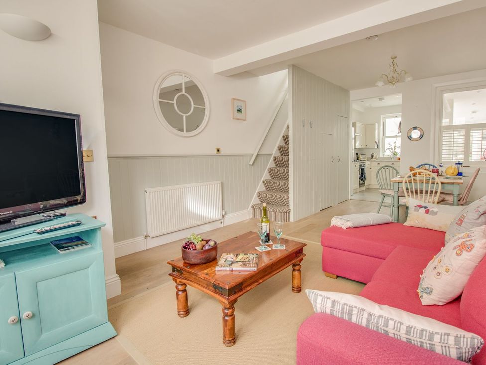 A living room with a sofa and television at Seahorse Cottage in Weymouth