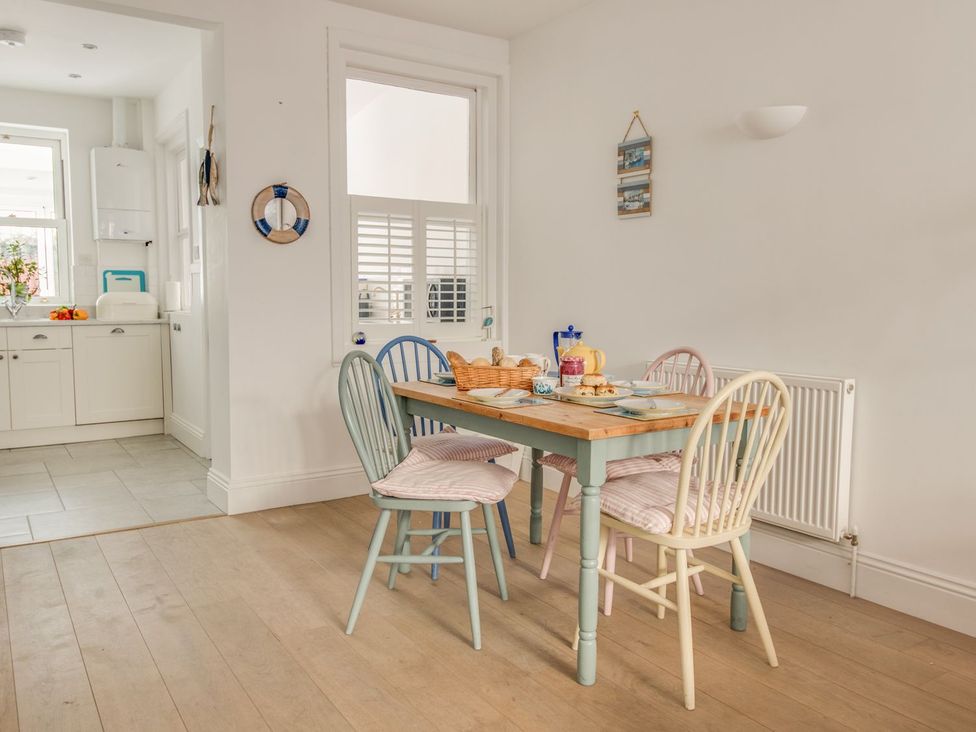 A dining room with a table and chairs at Seahorse Cottage in Weymouth