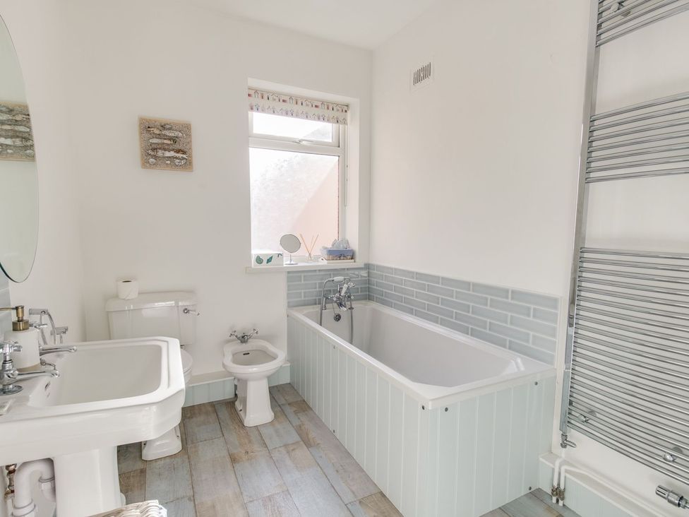 A bathroom with a bathtub, sink, toilet, and bidet at Seahorse Cottage, Weymouth