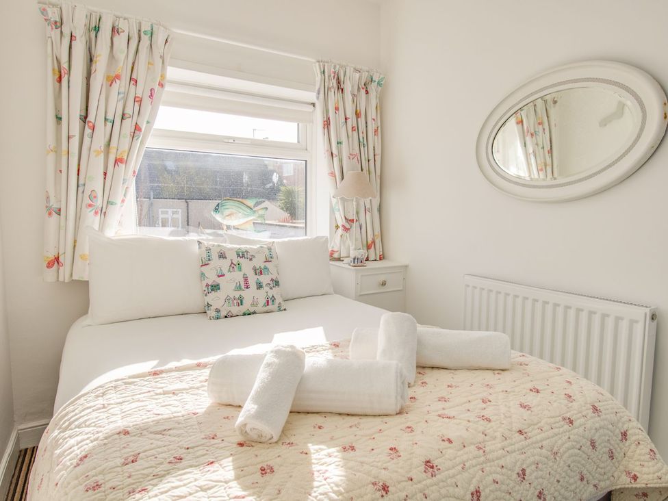 A bedroom with a bed and decorative pillows at Seahorse Cottage in Weymouth