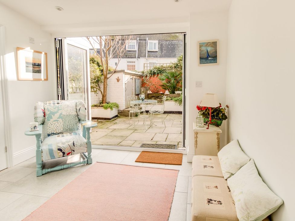 A living room with a chair and garden view at Seahorse Cottage in Weymouth