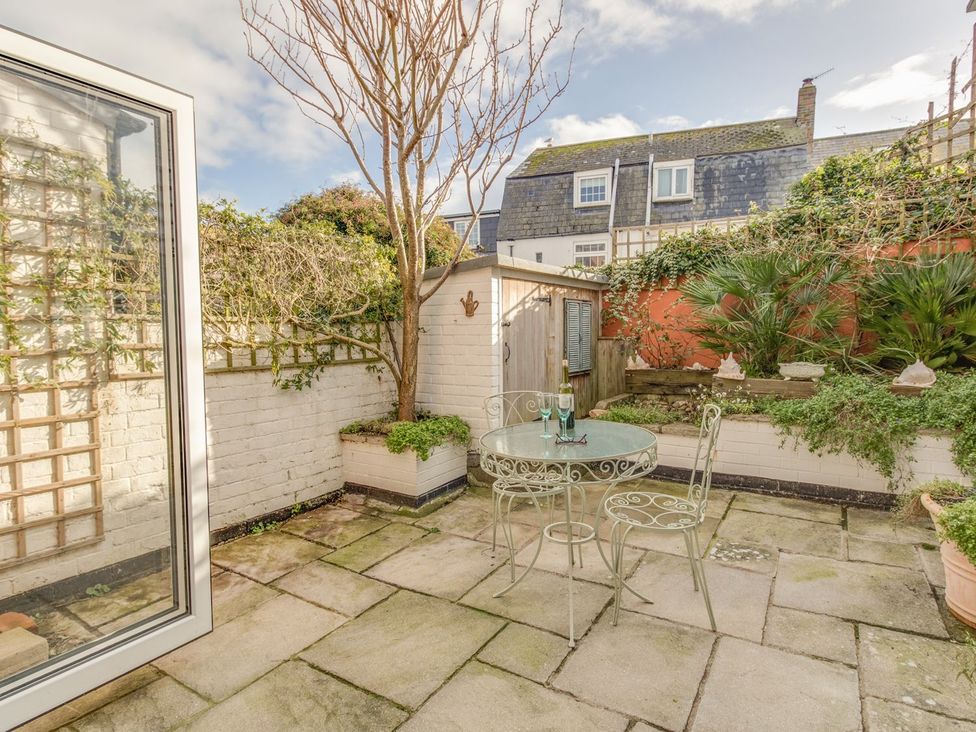 A garden with a table and chairs at Seahorse Cottage Weymouth