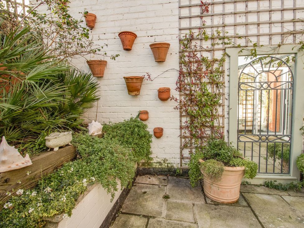 A garden with wall planters and potted plants at Seahorse Cottage in Weymouth