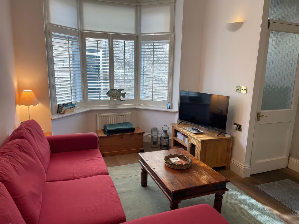 A living room with a sofa and television at Seahorse Cottage in Weymouth