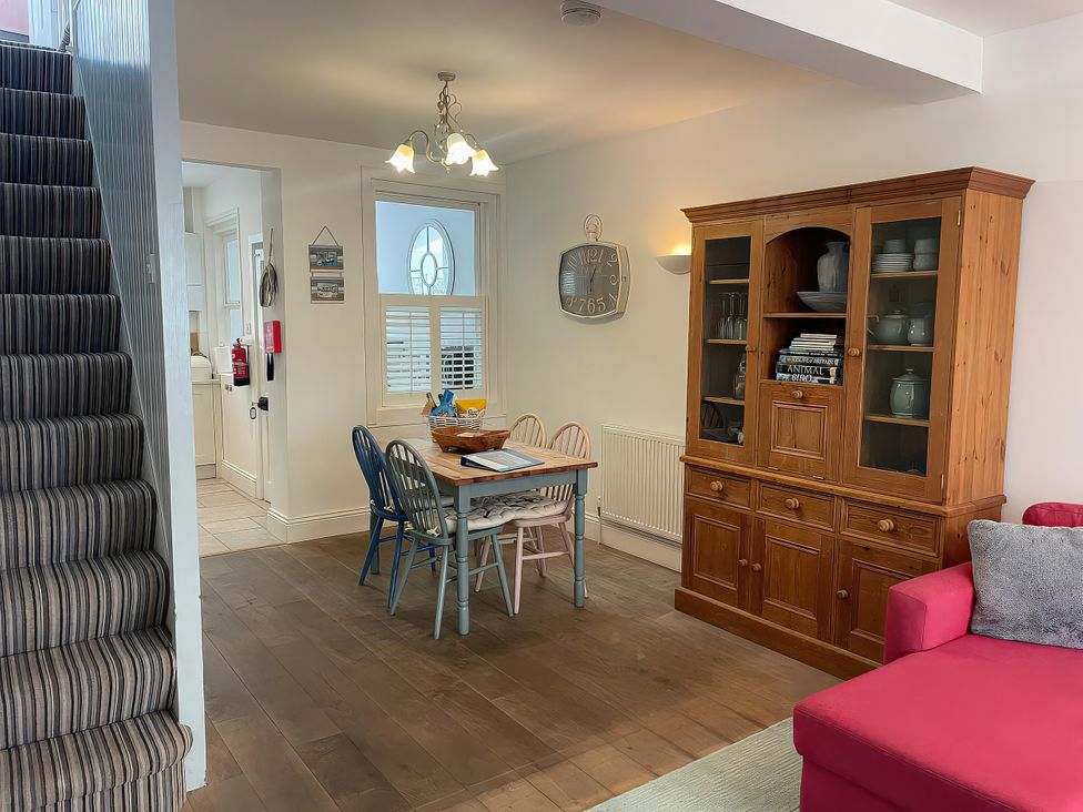 A dining room with a table and chairs at Seahorse Cottage in Weymouth