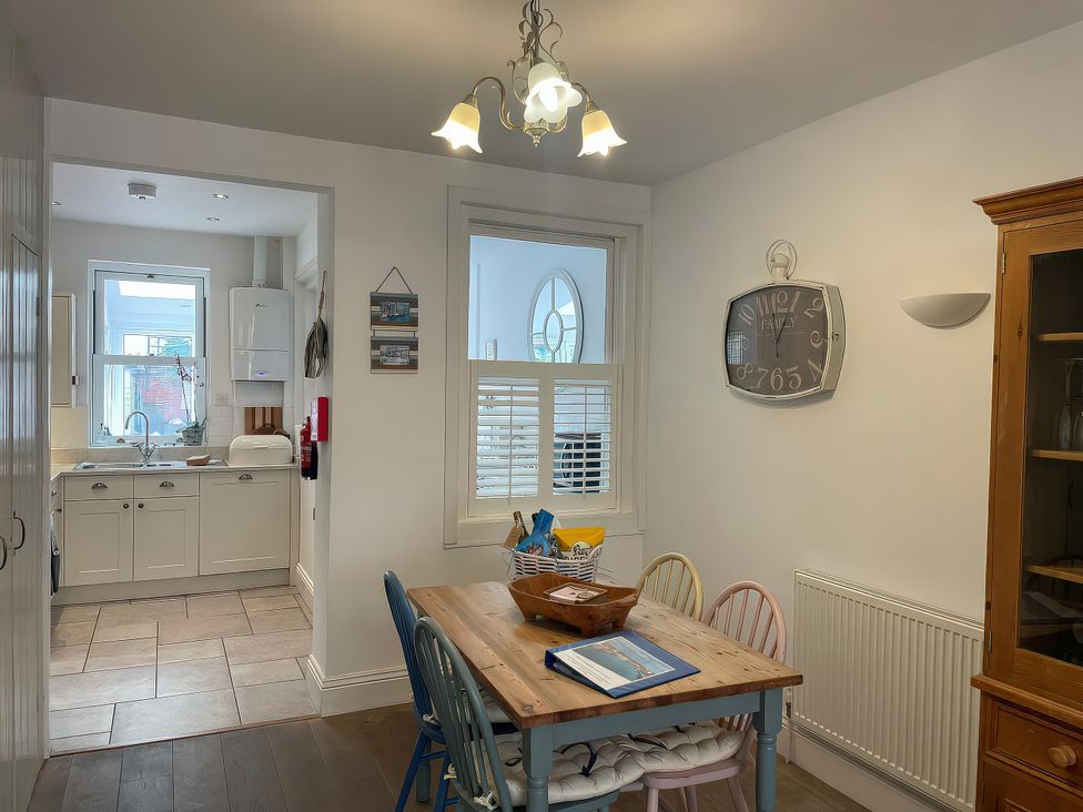 A kitchen with a table and chairs at Seahorse Cottage in Weymouth