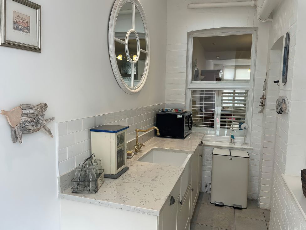 A kitchen with a sink and microwave at Seahorse Cottage in Weymouth