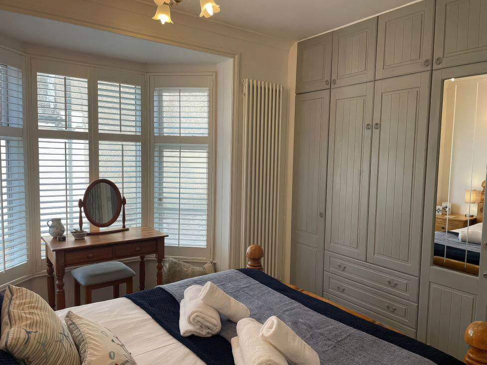 A bedroom with a bed and dressing table at Seahorse Cottage in Weymouth