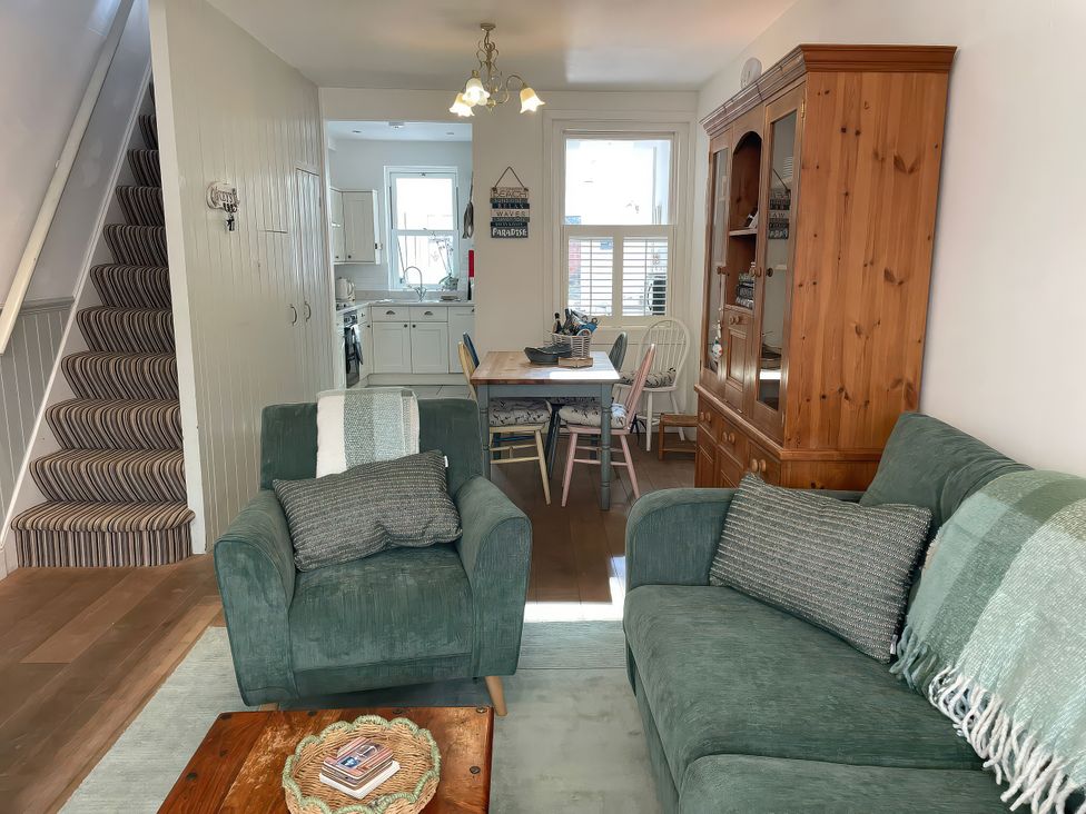 A living room with furniture and a dining area at Seahorse Cottage in Weymouth