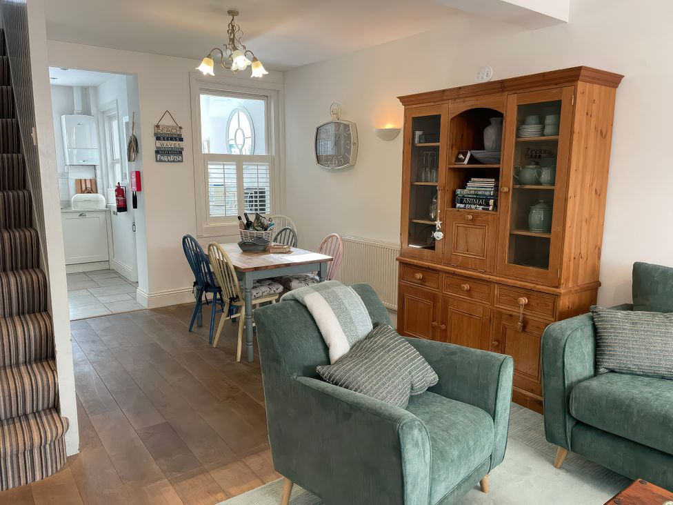 A dining room with a table and chairs at Seahorse Cottage in Weymouth