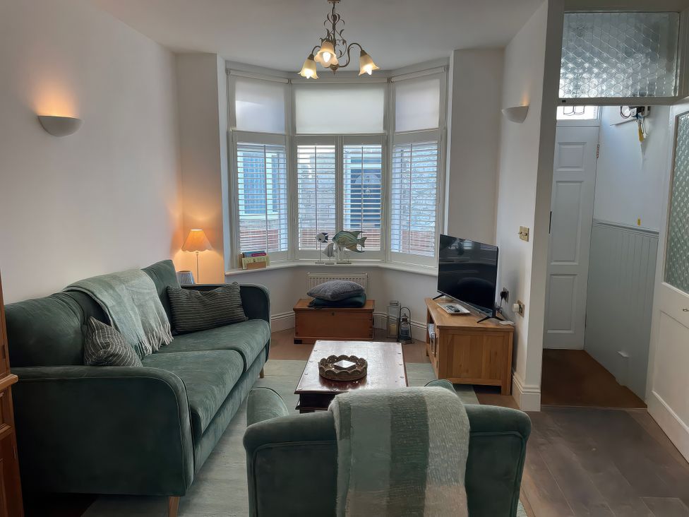 A living room with a sofa and television at Seahorse Cottage in Weymouth