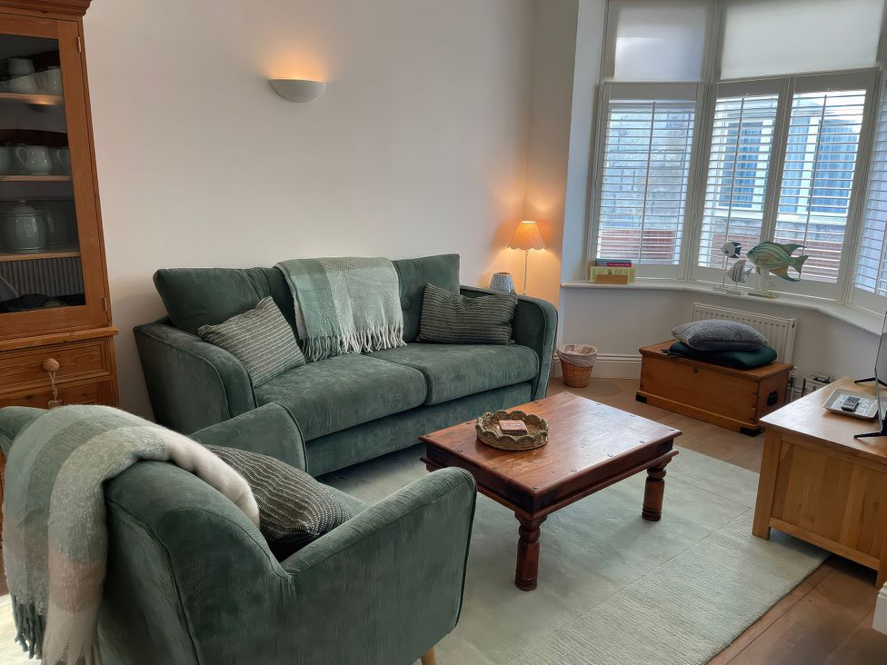 A living room with a sofa and coffee table at Seahorse Cottage in Weymouth