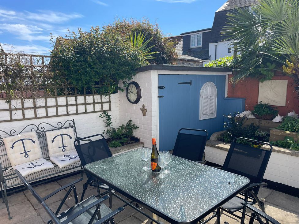 A garden with a table and chairs at Seahorse Cottage in Weymouth