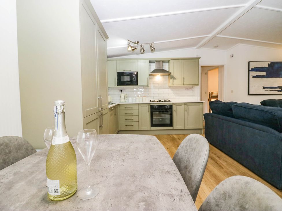 A kitchen with a table and champagne at Terabitha Lodge in Troutbeck
