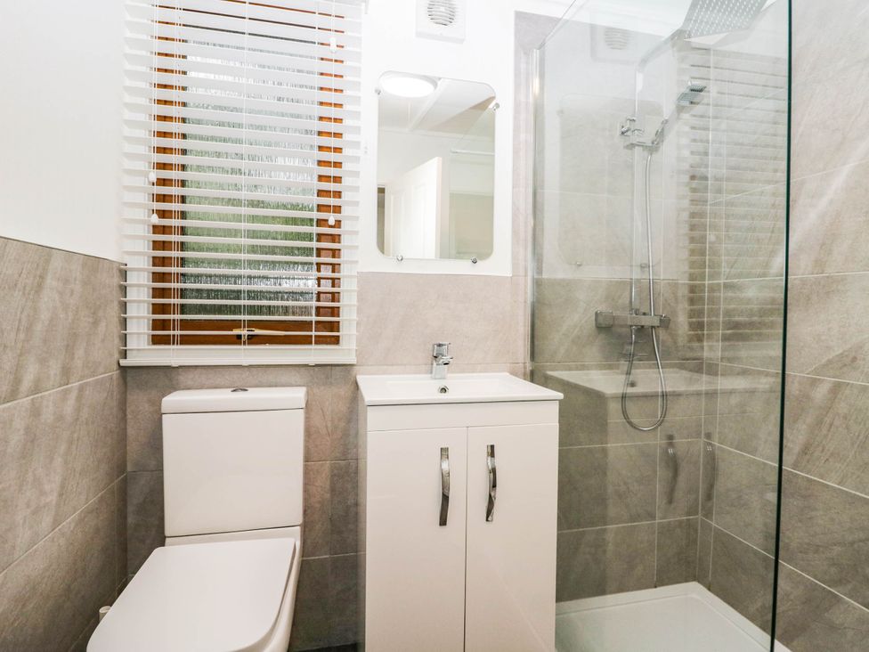 A bathroom with a shower and vanity at Terabitha Lodge in Troutbeck
