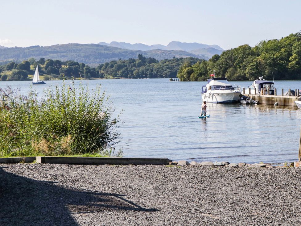 A lake scene with boats and a person on a paddle board at Terabitha Lodge Troutbeck