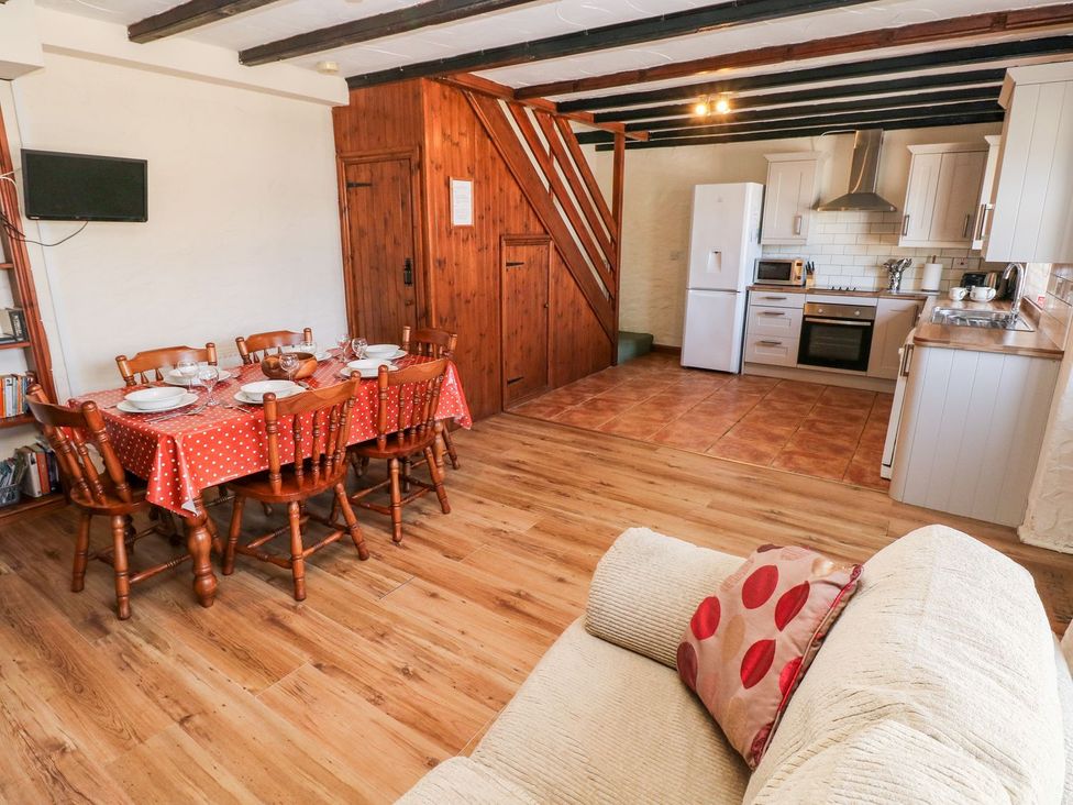 A living room with a dining table and kitchen area at Ty Fferm in Newport
