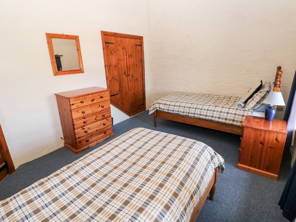 A bedroom with two beds and a dresser at Ty Fferm in Newport