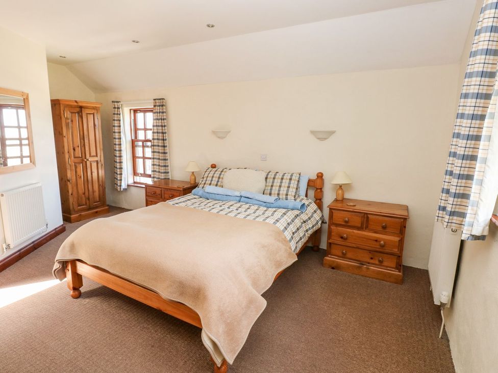 A bedroom with a bed and wardrobe at Ty Fferm in Newport