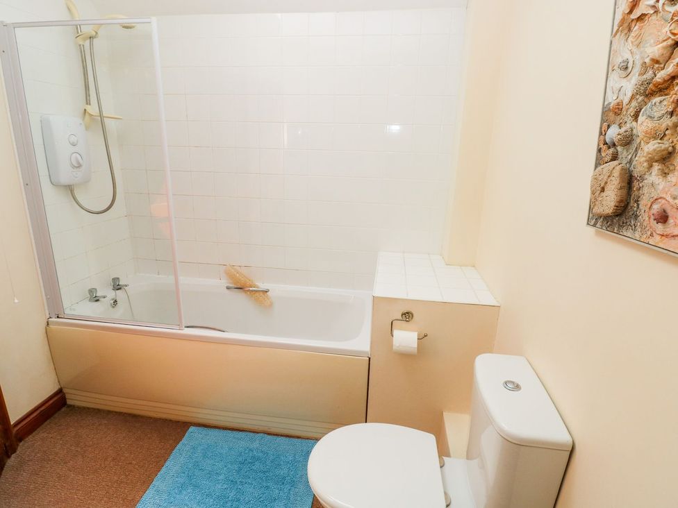A bathroom with a bath tub and toilet at Ty Fferm in Newport