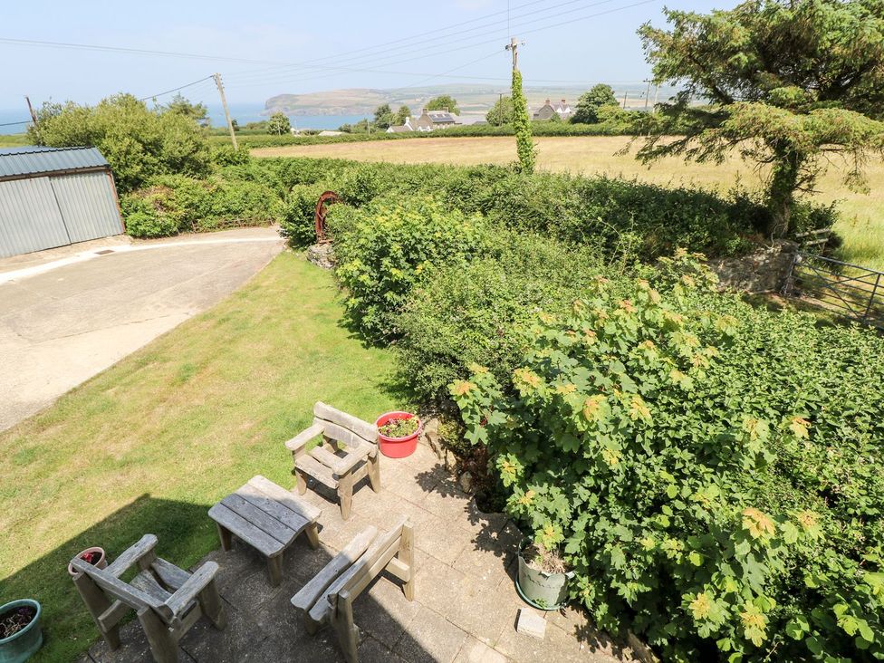 A garden with seating and a view of the sea at Ty Fferm in Newport