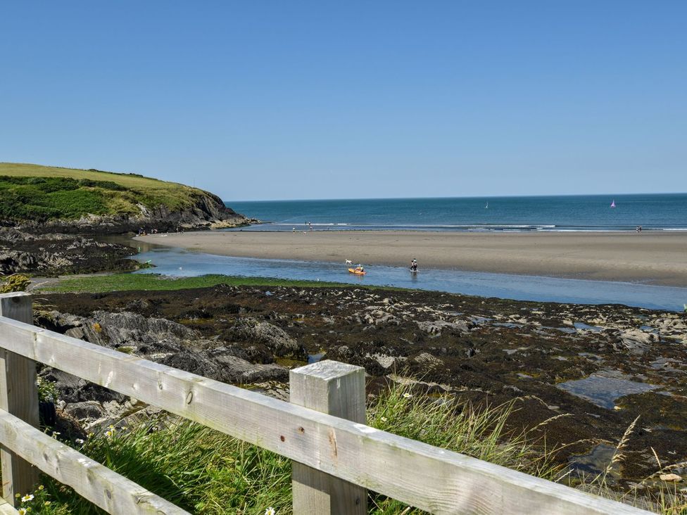 A beach with water and people near a fence at Ty Fferm in Newport