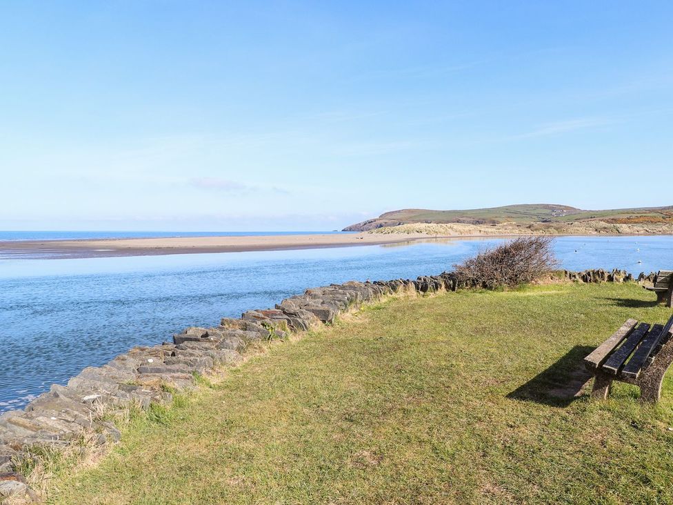 A view of the sea and grass with a bench at Ty Fferm in Newport
