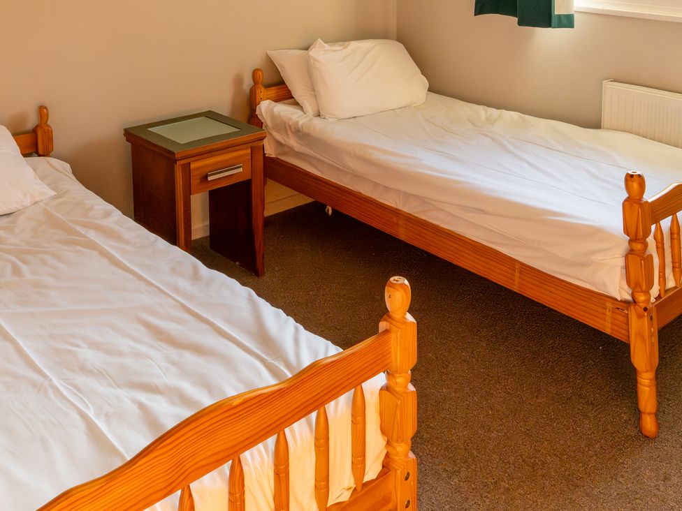 A bedroom with two single beds and a nightstand at 2 bedroom Cabin No.1 Port Talbot