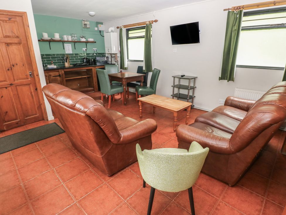 A living room with a sofa, table and TV at Cabin No. 13 - Salt and Fern Cabins, Goytre near Port Talbot