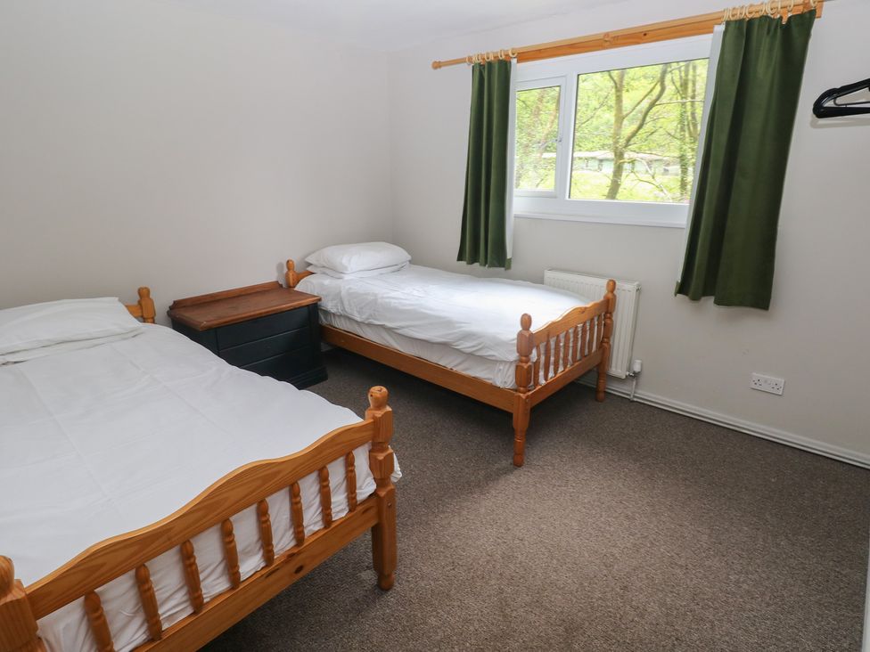 A bedroom with two beds and a dresser at Cabin No. 13 - Salt and Fern Cabins, Goytre near Port Talbot