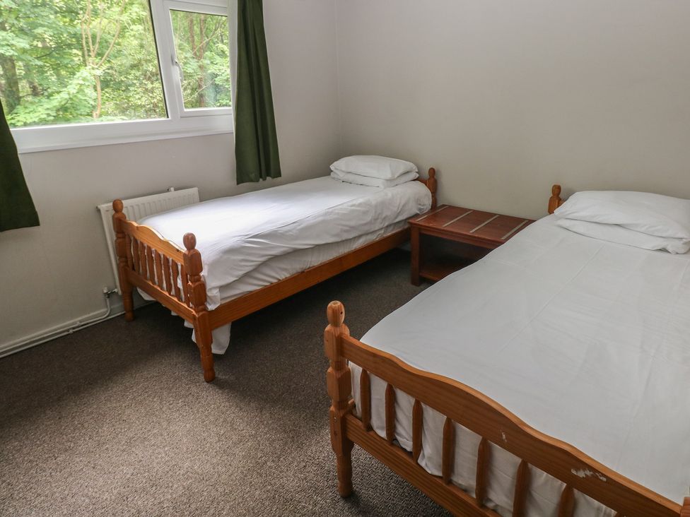 A bedroom with two beds and a table at Cabin No. 13 - Salt and Fern Cabins Goytre near Port Talbot