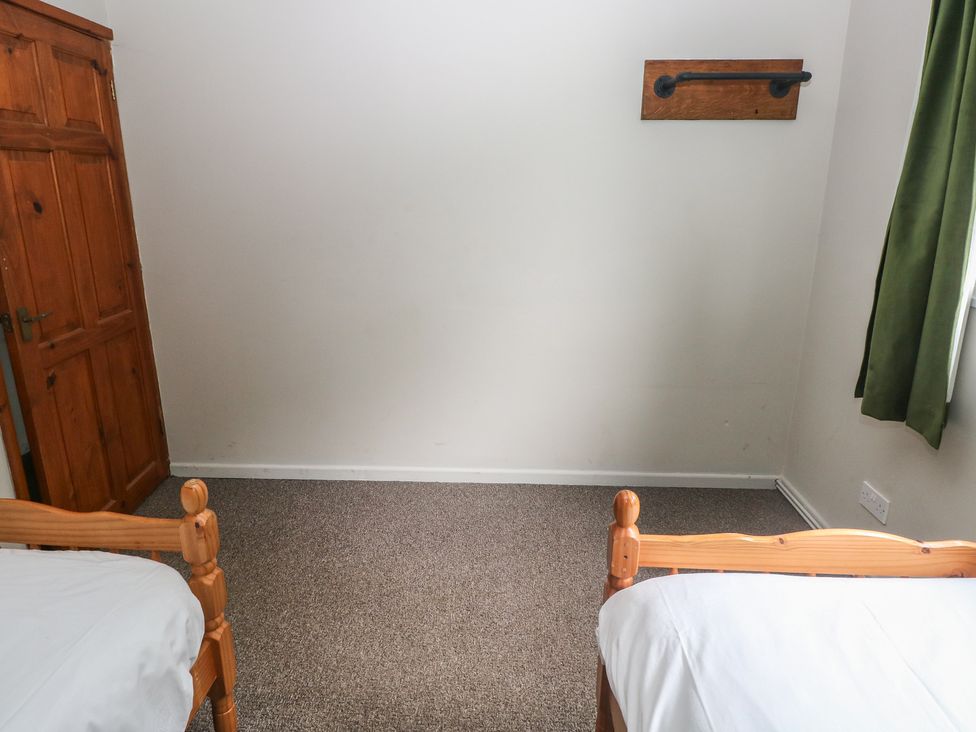 A bedroom with two beds and a wardrobe at Cabin No. 13 - Salt and Fern Cabins Goytre near Port Talbot