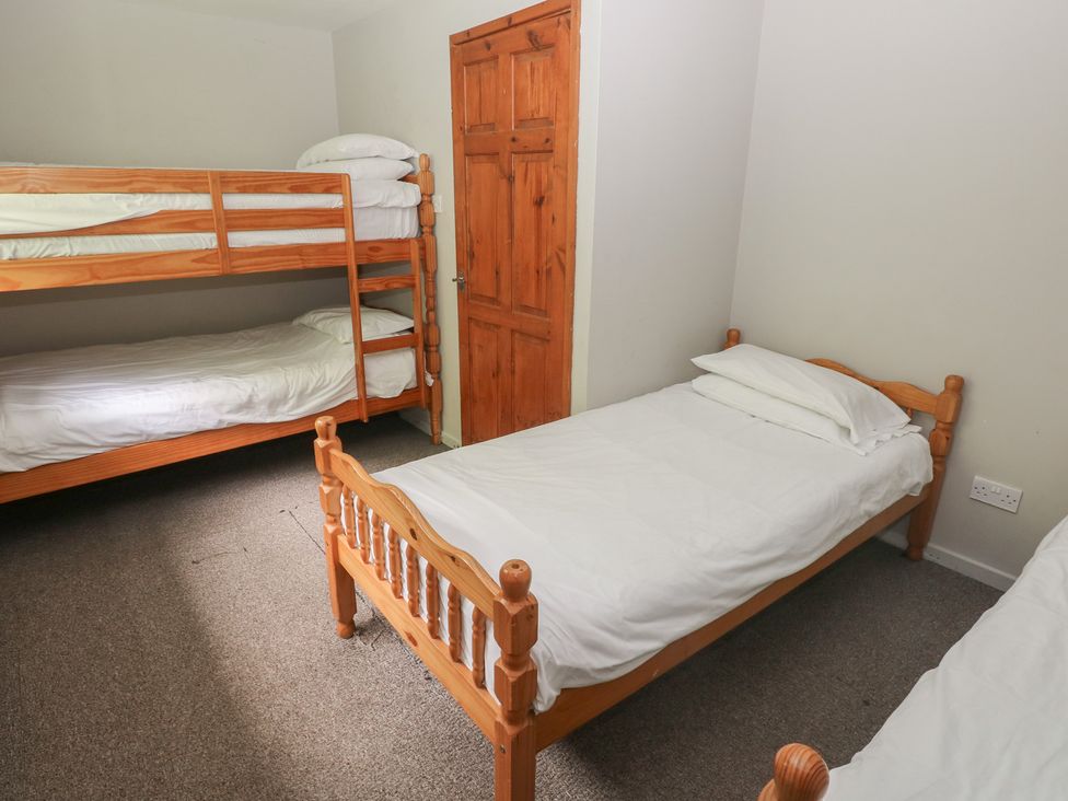 A bedroom with a bunk bed and a single bed at Cabin No. 13 - Salt and Fern Cabins Goytre near Port Talbot