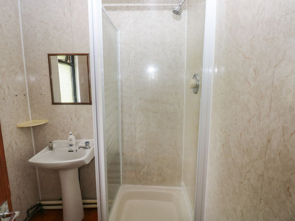 A bathroom with a shower and hand basin at Cabin No. 13 - Salt and Fern Cabins Goytre near Port Talbot