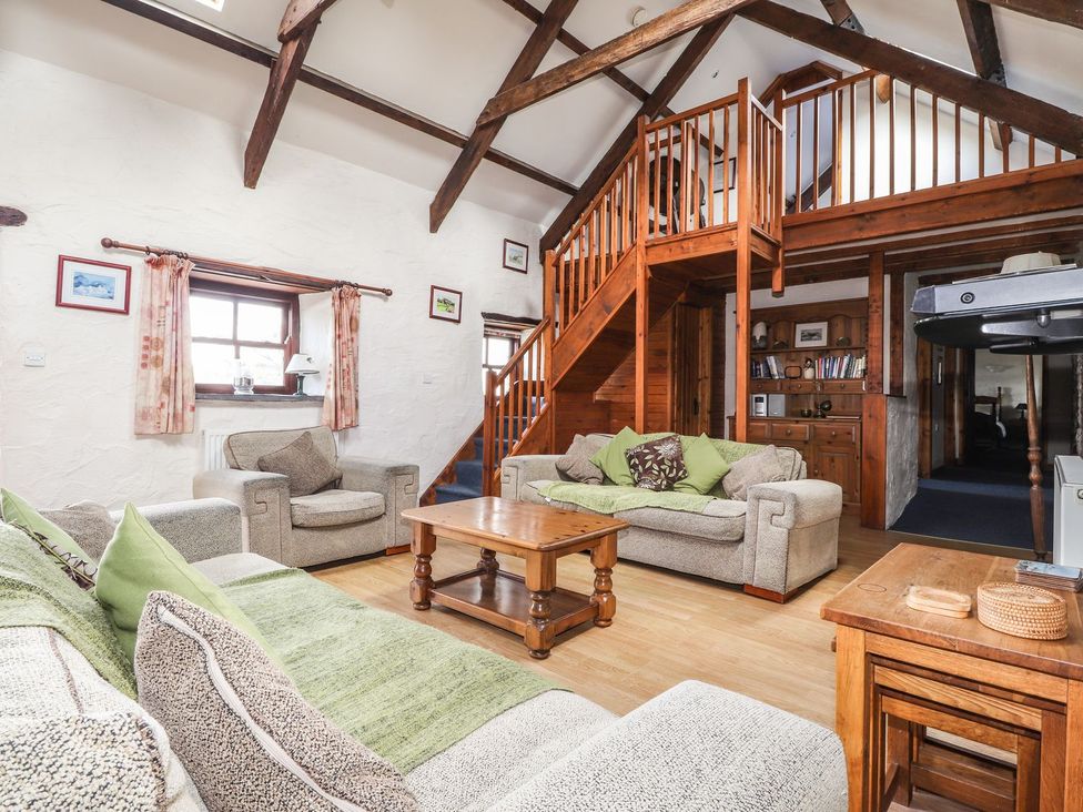 A living room with sofas and a staircase at Ty Felin Newport